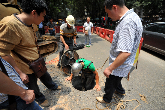 搶修人員進(jìn)入地下查找造成事故的原因。  